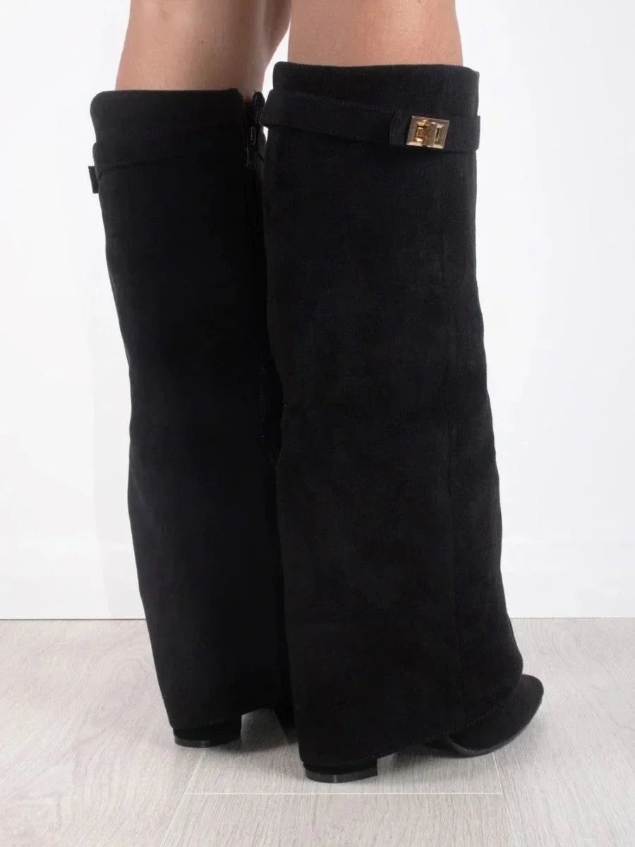 Bottes en suède noir pour femme, avec détails métalliques et design classique.